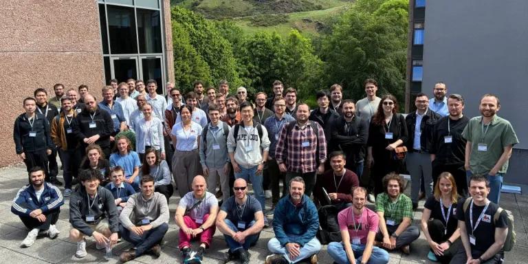 A group photo of the workshop attendees. They are gathered outside in the sun.