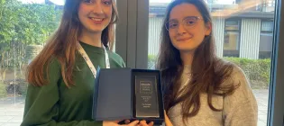 Two members of Piscopia hold their trophy 