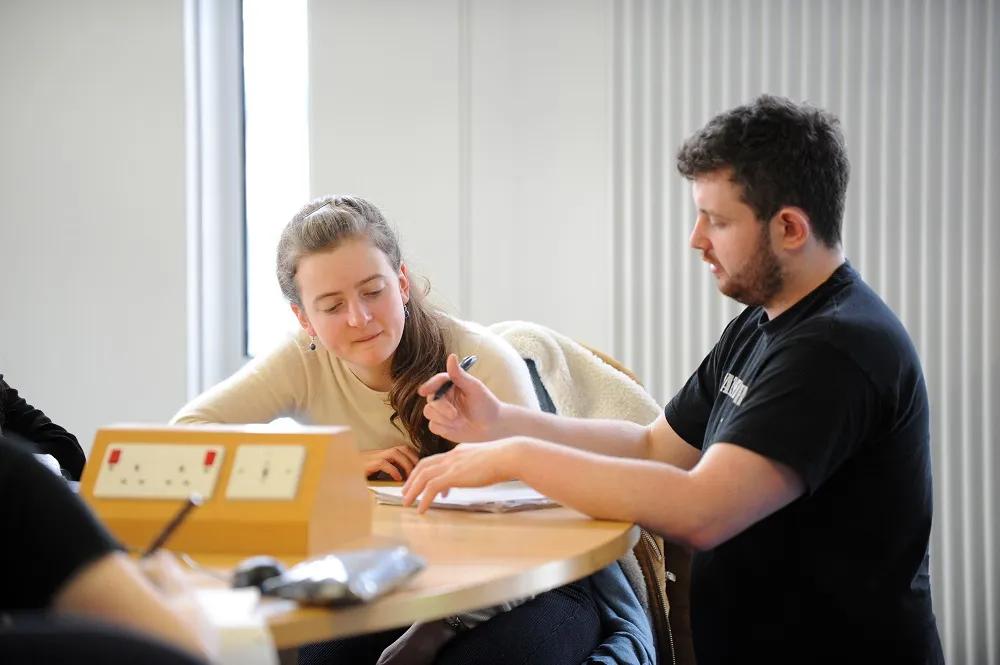 Tutor helping a student in a workshop