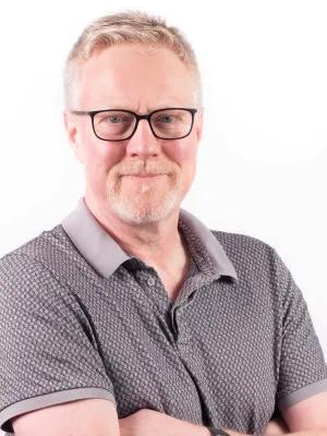 headshot of Des with his arms folded looking to camera