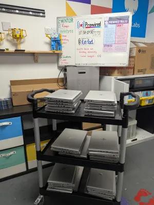 A photo of a trolley stacked with laptops